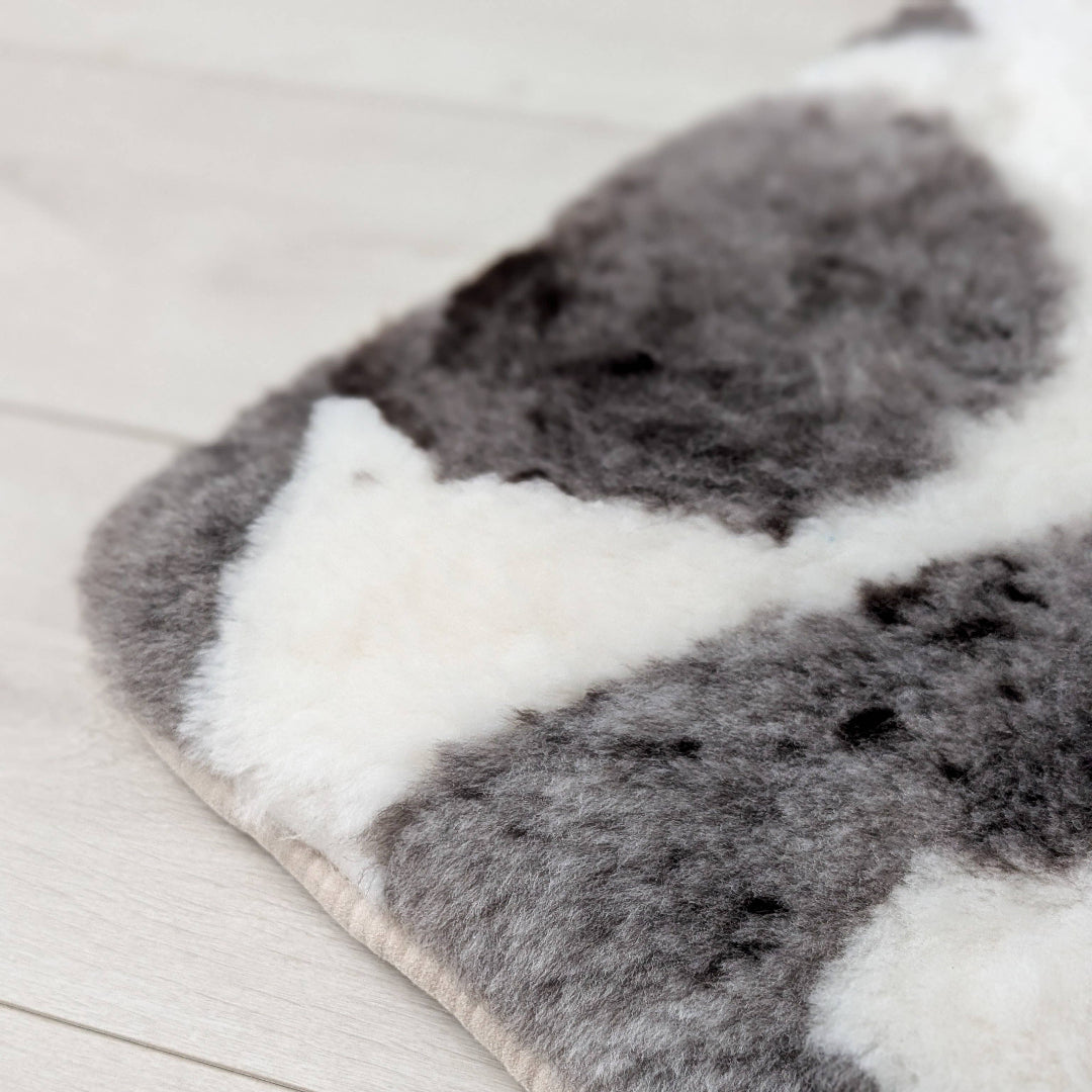 corner of a natural brown and white sheepskin seat pad on a beige background