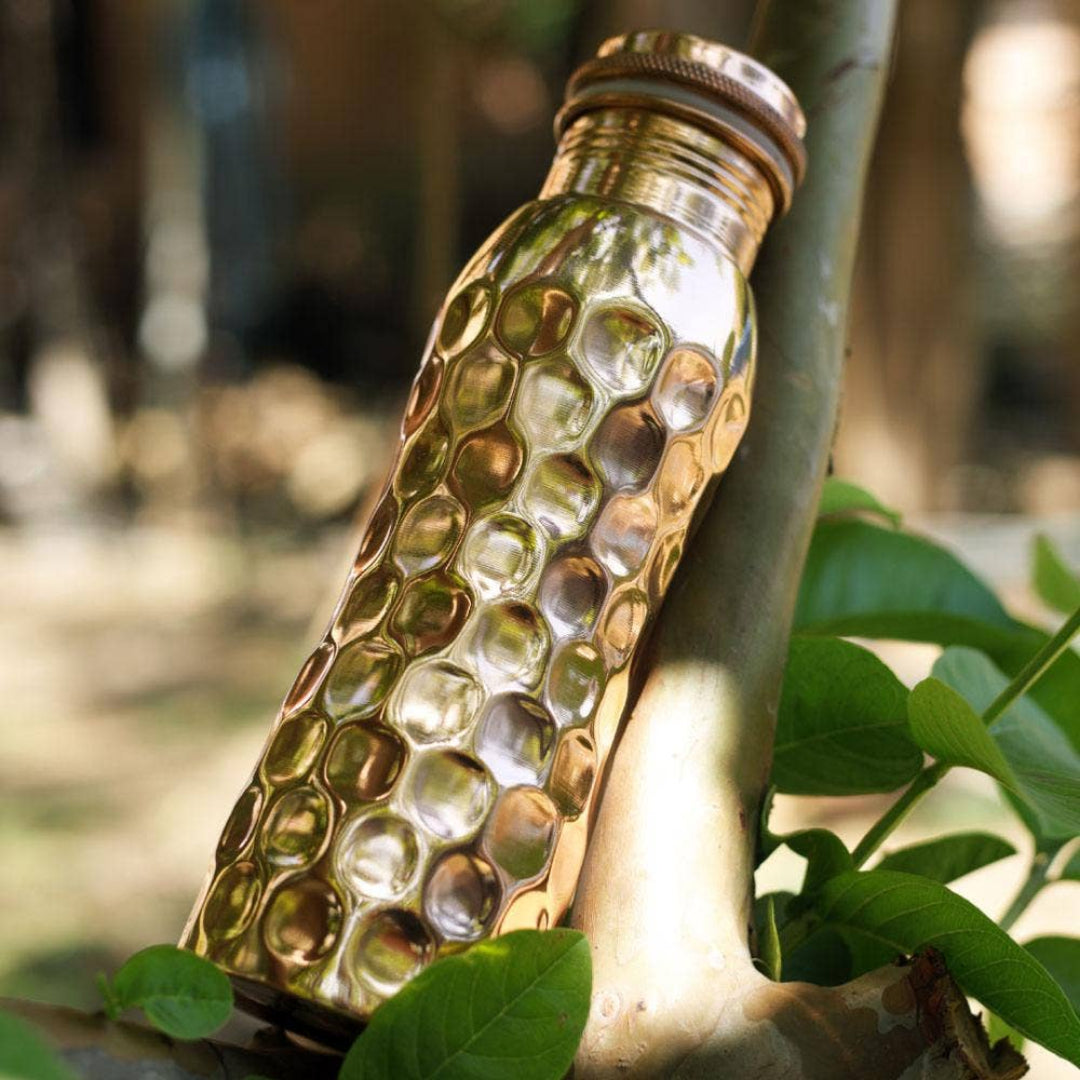 Copper water bottle with honeycomb pattern on a natural background