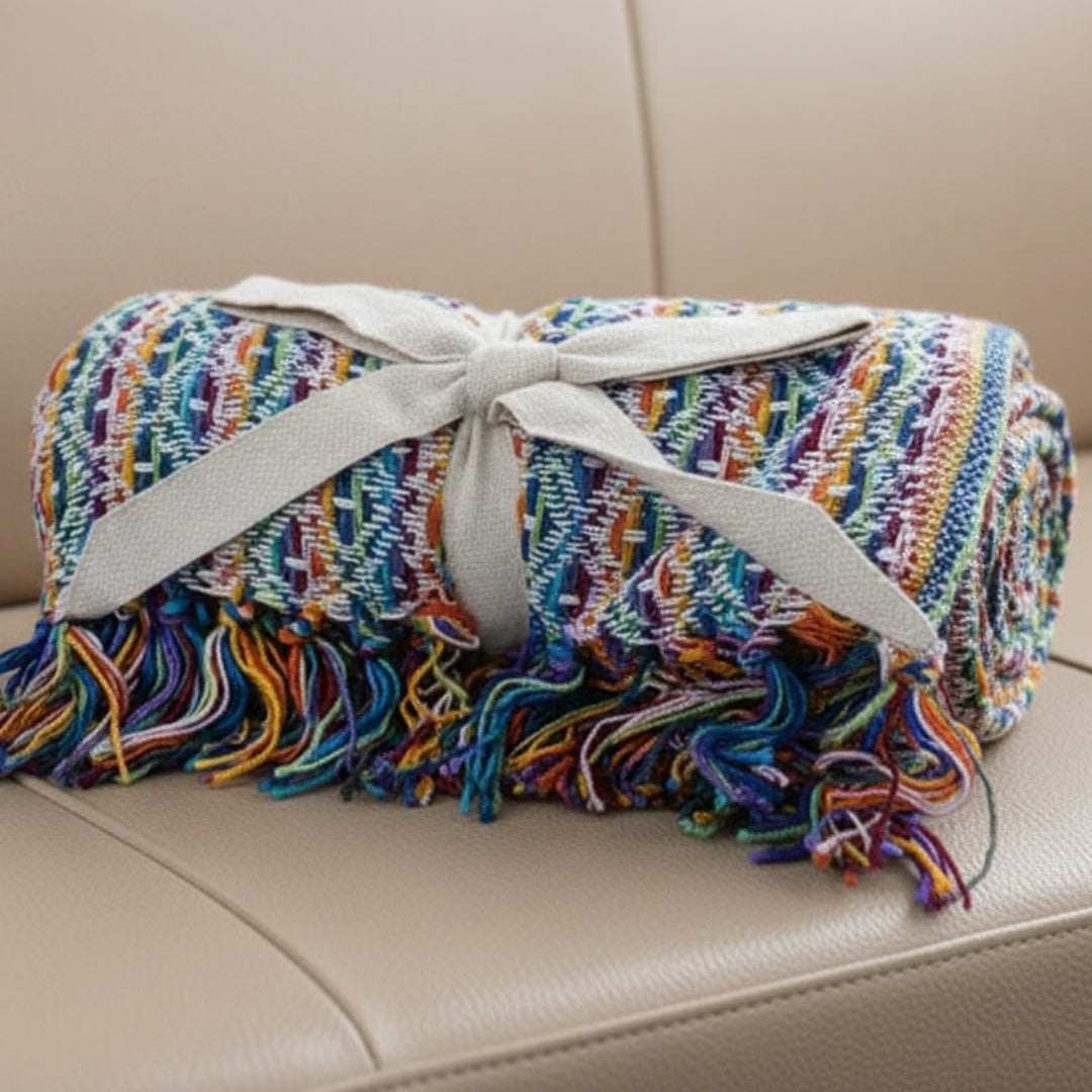 Multicolored woven blanket with tassels on a beige background
