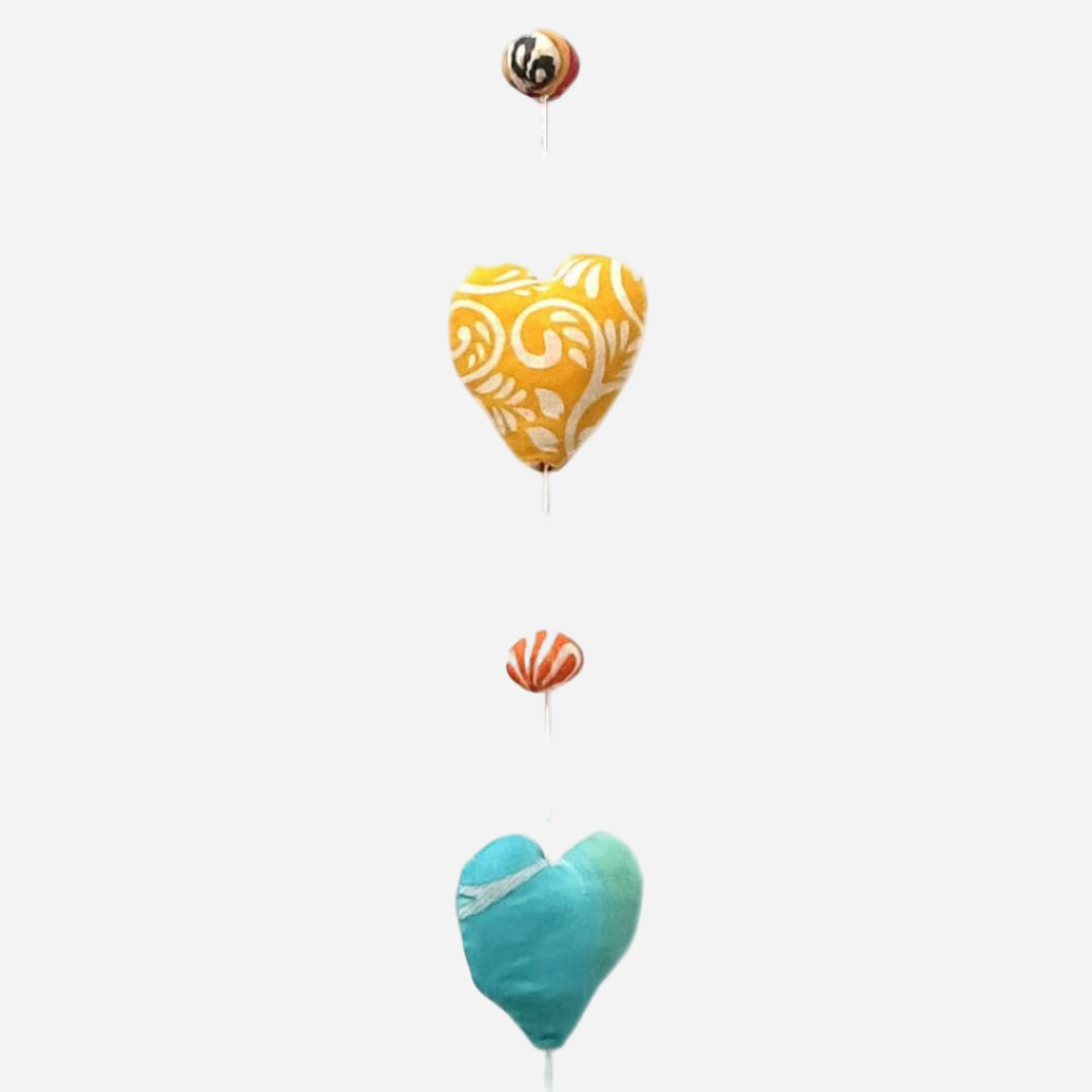Decorative heart-shaped mobile with yellow and blue hearts on a white string