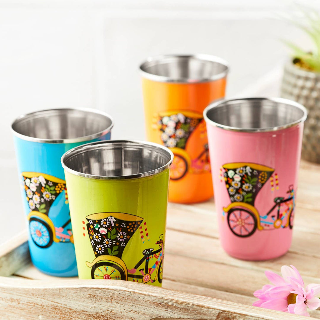 Set of four colorful stainless steel tumblers with rickshaw designs displayed on a wooden tray.