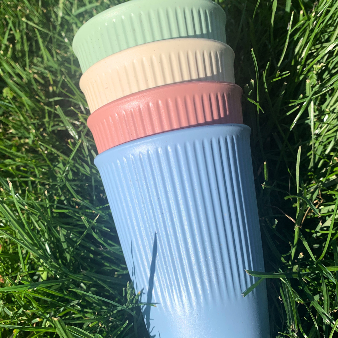 Stack of colorful cups on grass