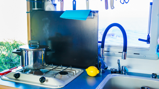 campervan kitchenette with pot on the stove and a lemon next to the sink