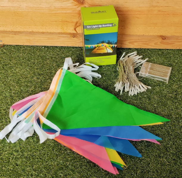 Multicoloured triangular bunting flags with white string. Separate string of white fairy lights. Displayed in front of box.