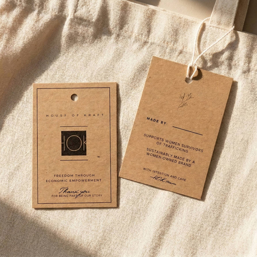 Two brown paper tags on a beige fabric background