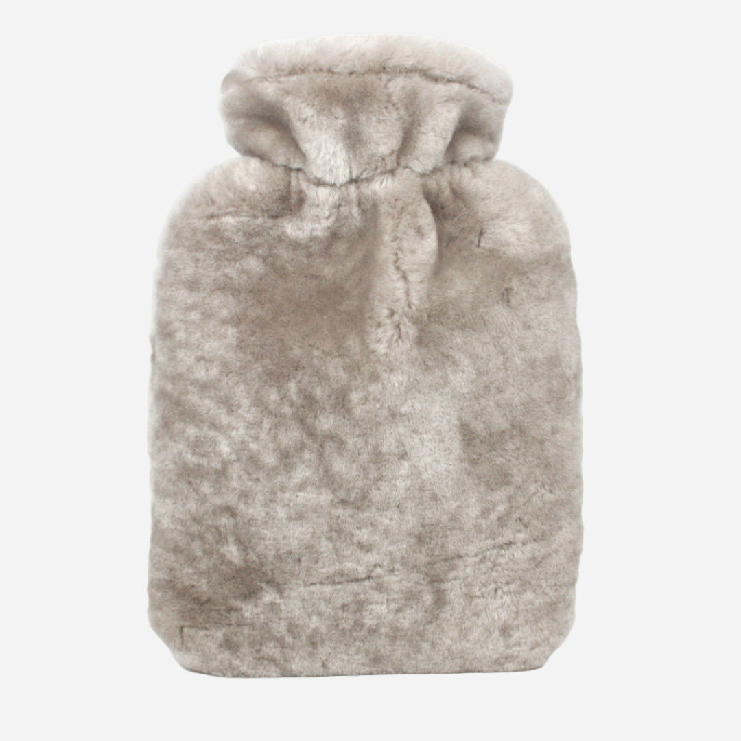 beige sheepskin hot water bottle on grey background