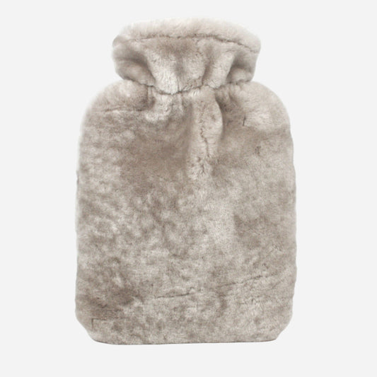 beige sheepskin hot water bottle on grey background