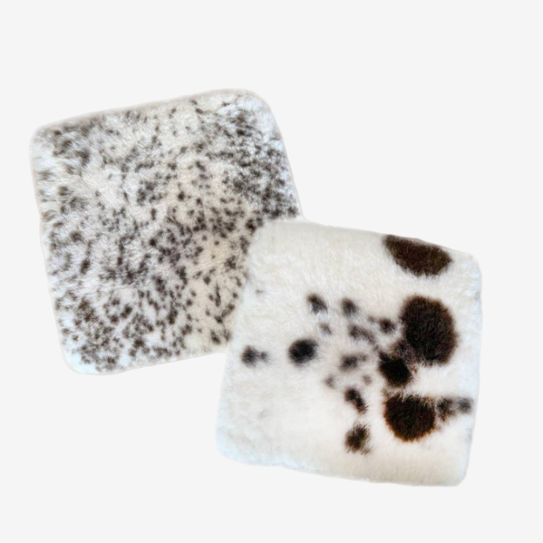 natural sheepskin seat pads with brown spots on a grey background