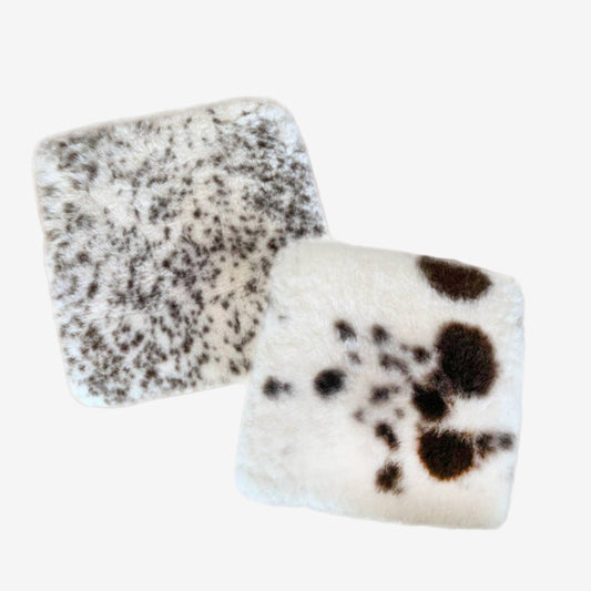 natural sheepskin seat pads with brown spots on a grey background