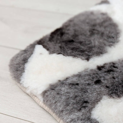 corner of a natural brown and white sheepskin seat pad on a beige background