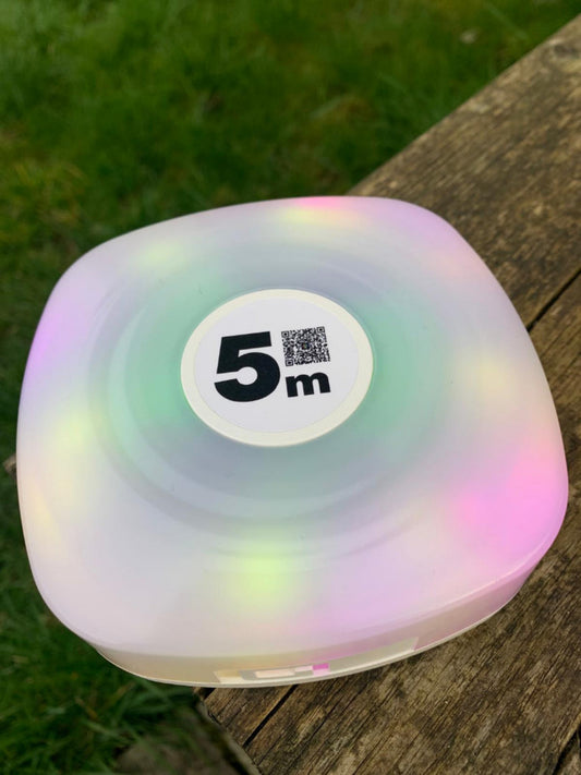 Camping string light storage, rounded square shape, switched on with multi-colour lights.