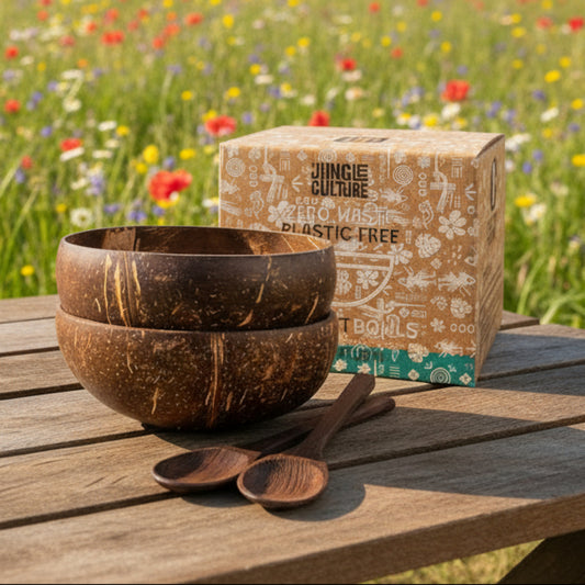Set of coconut bowls and wooden spoons with a 'Jungle Culture' branded box on a spring field background.