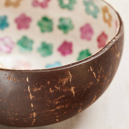 Coconut shell bowl with floral patterned interior on a white background