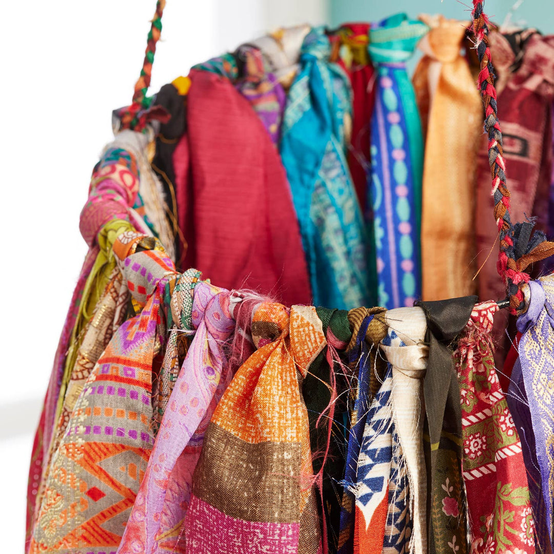 Colorful sari fabrics on a hanging circle creating a wind chime