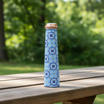 Tower copper water bottle with blue geometric pattern on a green background.