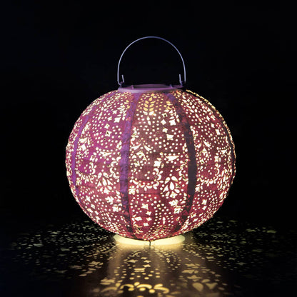 Decorative lantern with intricate cut-out patterns on a dark background
