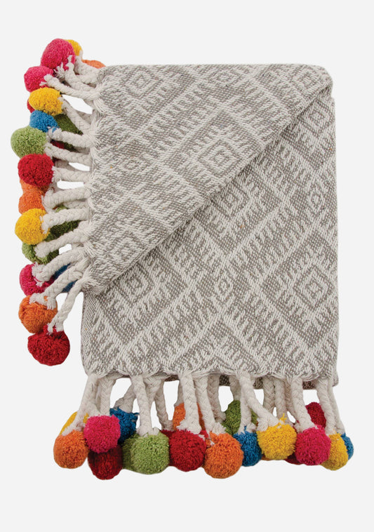 Textured light grey/white blanket with colourful pom-pom trim on a white background
