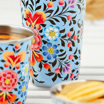 hand painted enamel large tumbler light blue background black leaves and stems, red-pink-blue-yellow flowers