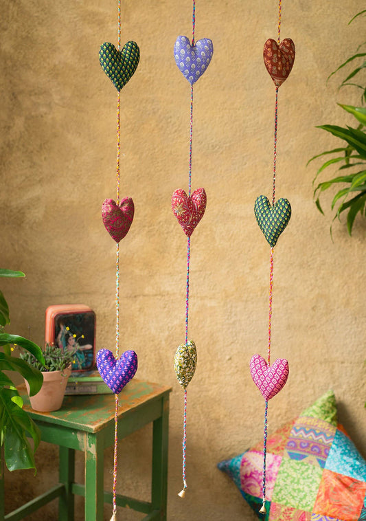 Three hanging heart strings with small bell on the end made from recycled sari material