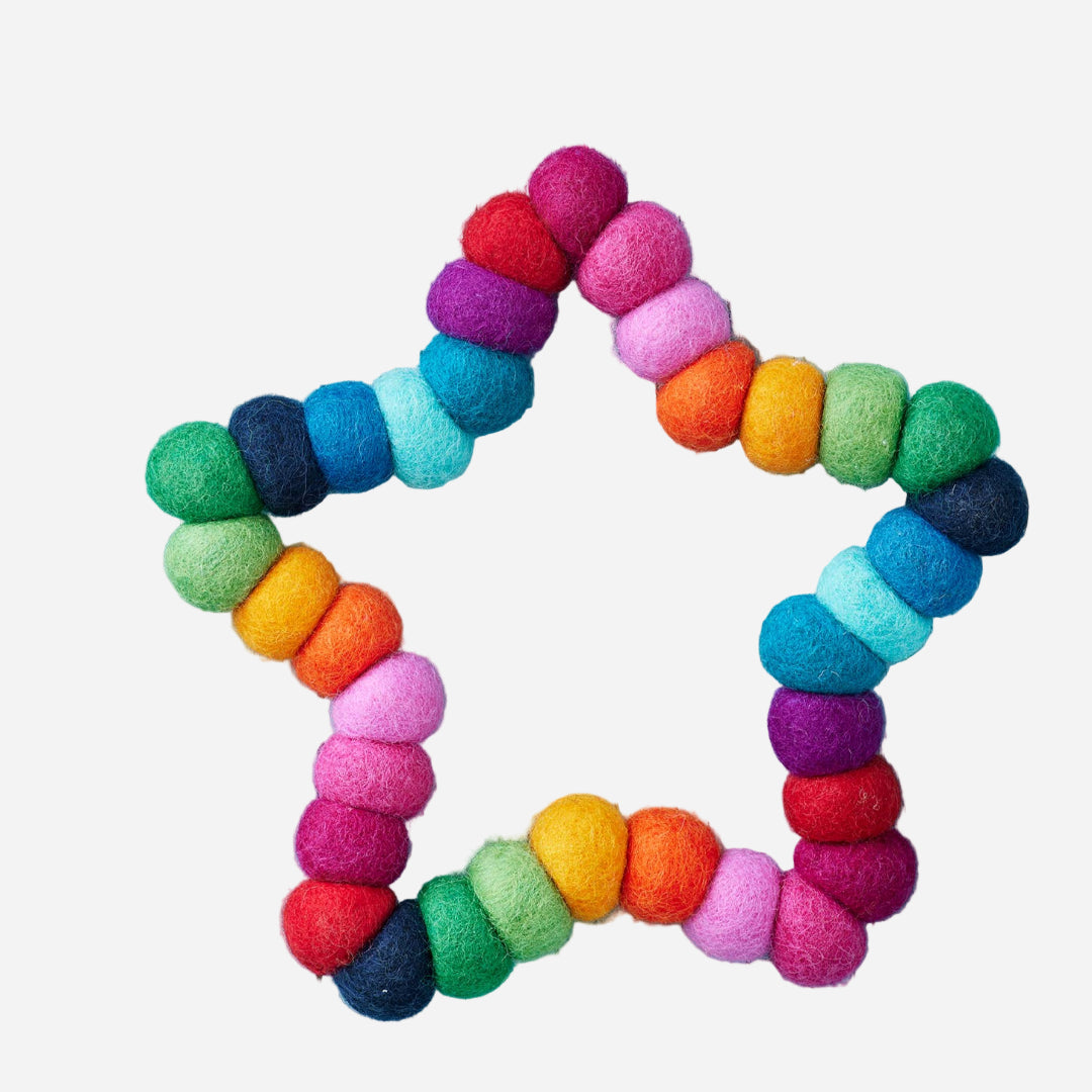 Colorful felt pompom star hanging on a blue wooden surface