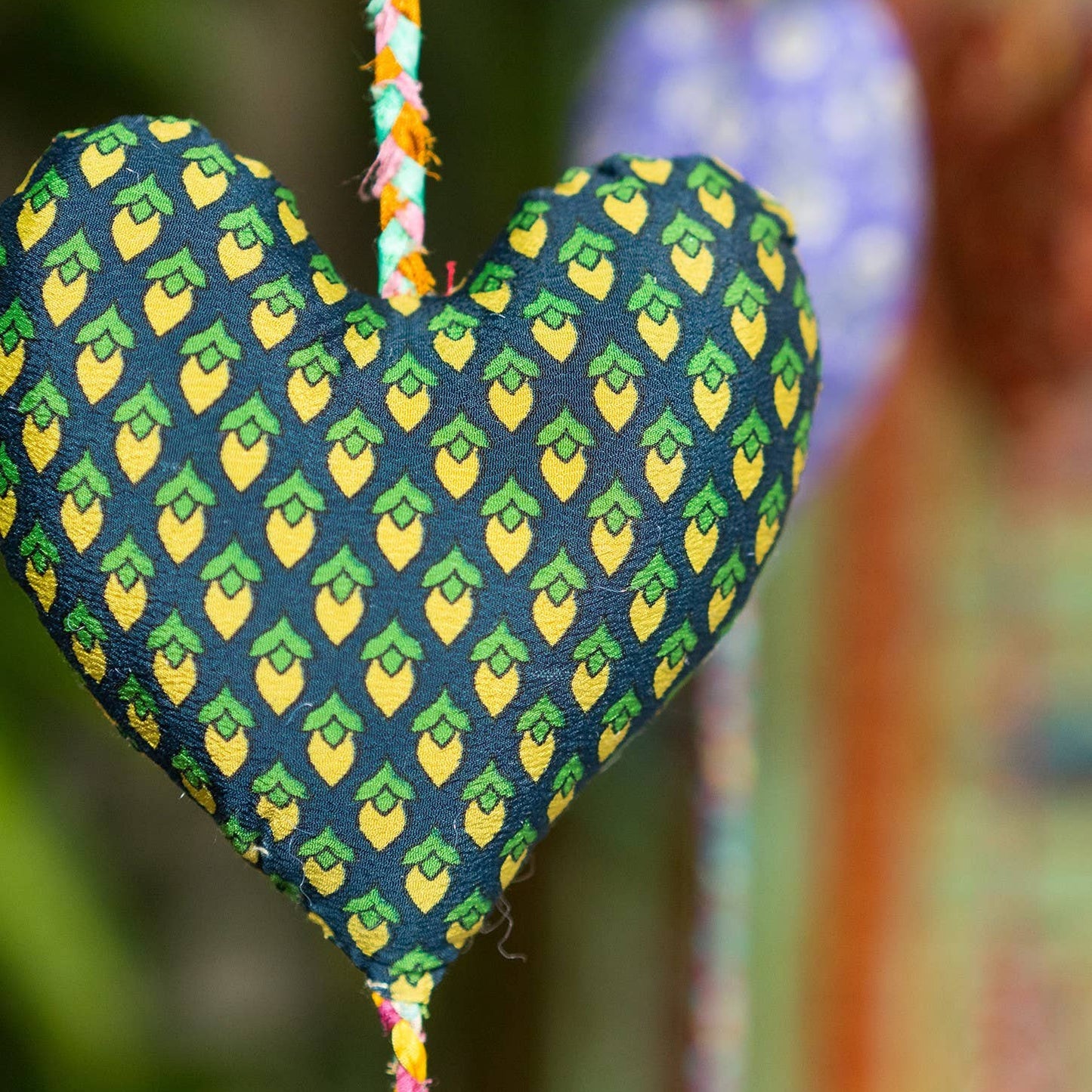 Single heart from decorative heart string. This heart is navy with yellow/green lemon-like print.