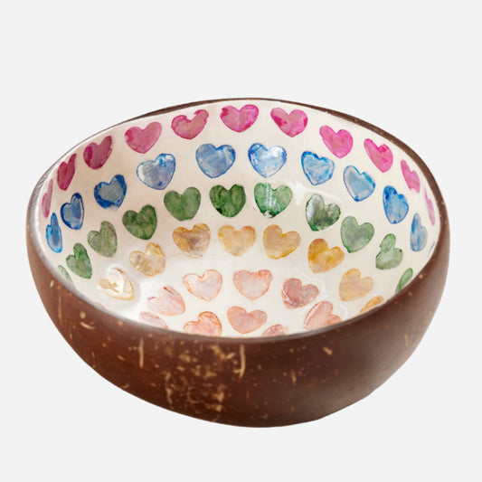 Coconut bowl with colorful heart patterns on a light background