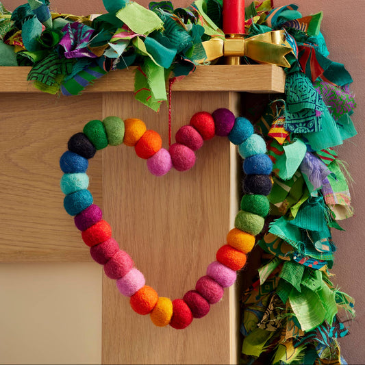 Colorful heart-shaped wreath hanging on a mantlepiece