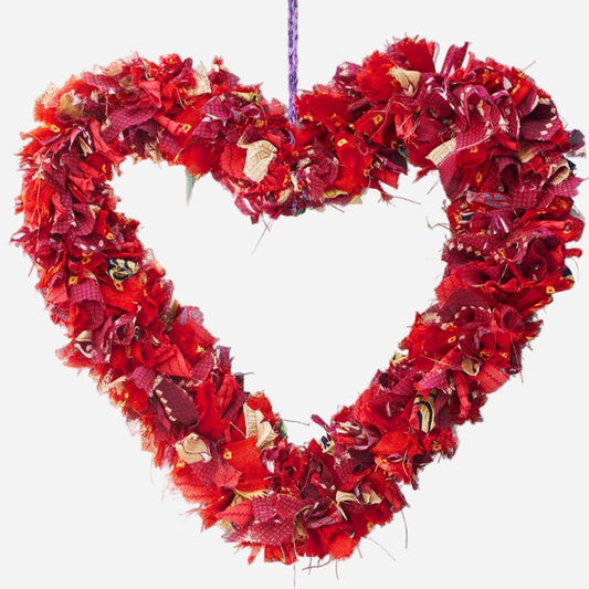 Heart-shaped wreath made of red fabric on a white background