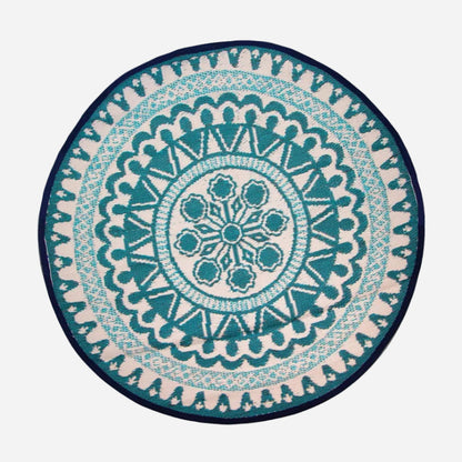 A round rug featuring a detailed teal and cream mandala pattern with a dark navy outer border, shown flat against a white background.
