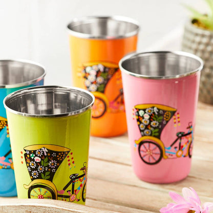 orange colourful stainless steel tumbler with rickshaw design displayed on a wooden tray.