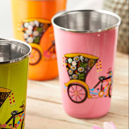 Pink stainless steel tumblers with rickshaw designs displayed on a wooden tray.