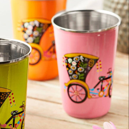 Pink stainless steel tumblers with rickshaw designs displayed on a wooden tray.