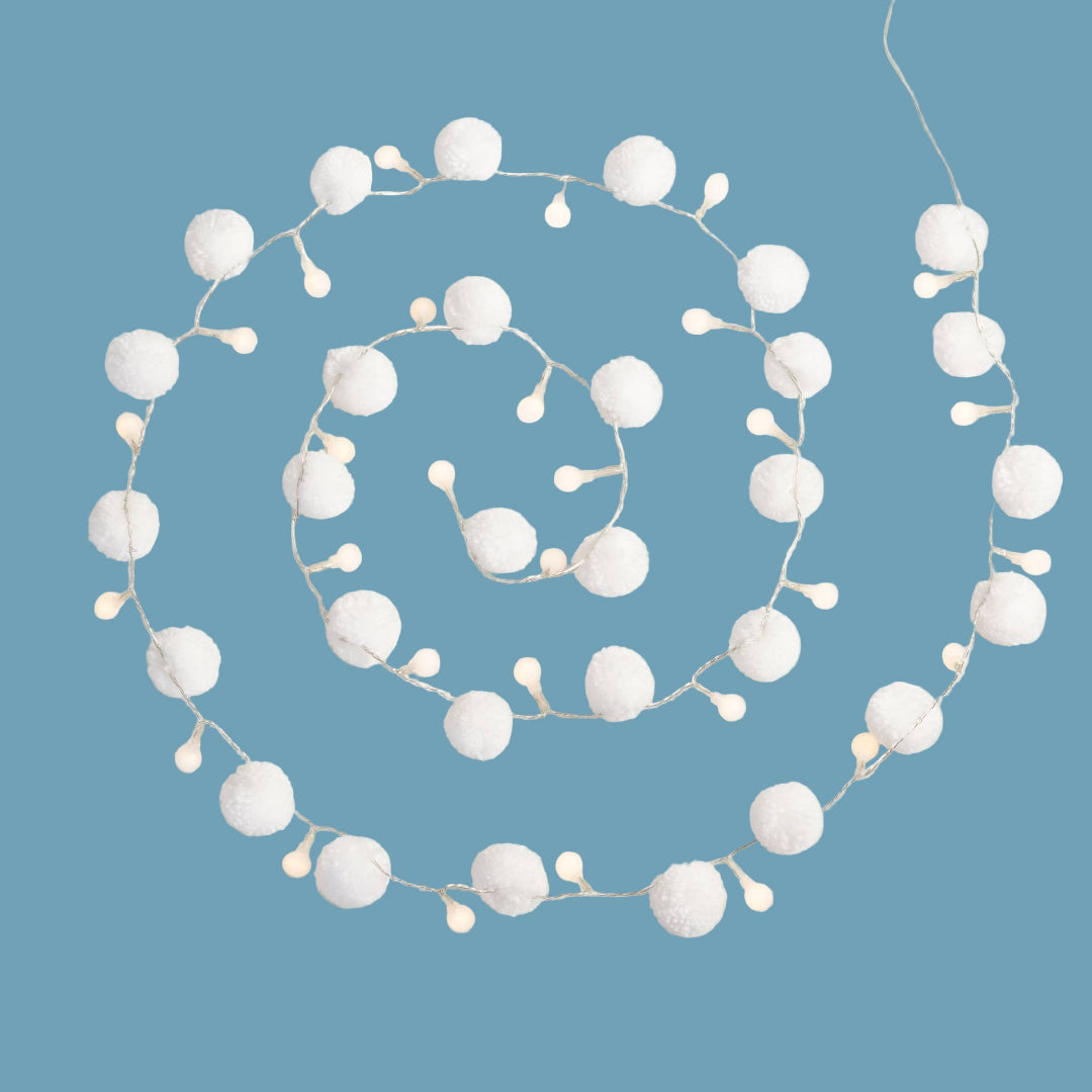 String of white pom-pom lights on a blue background