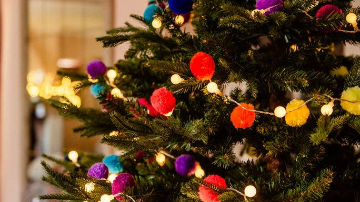Decorated Christmas tree with colorful pom-pom lights and fairy lights.