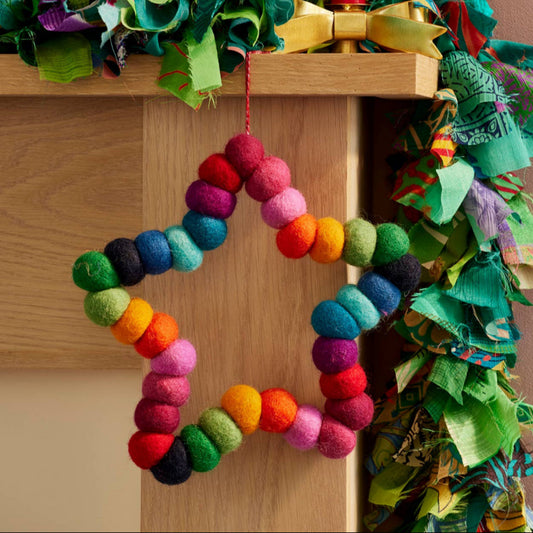 Decorative star wreath with colourful pompoms and a red hanging string