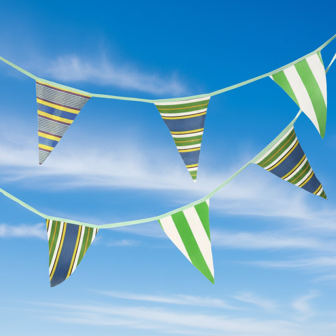 Striped bunting with green, blue, yellow and white colors on a blue sky background