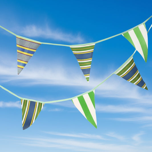 Striped bunting with green, blue, yellow and white colors on a blue sky background