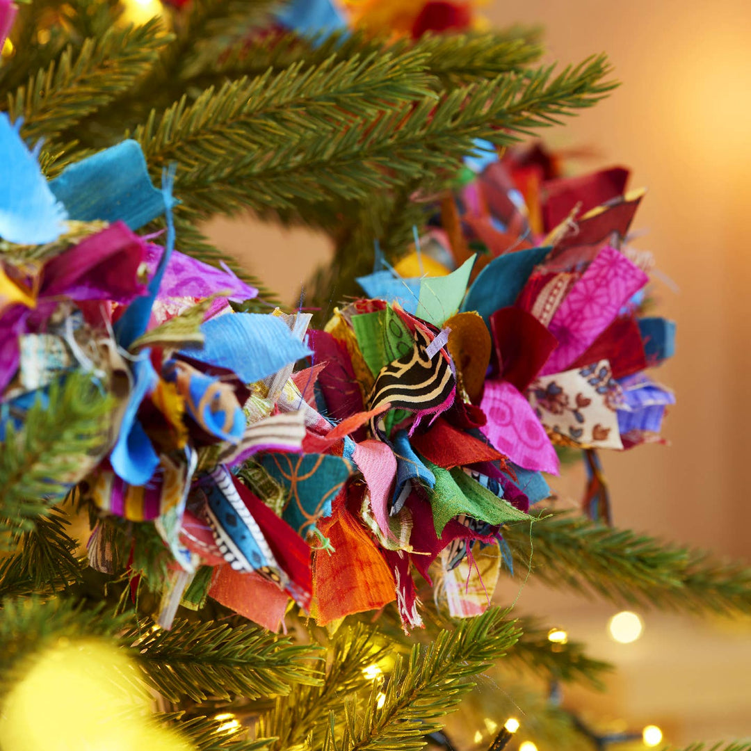 Colorful fabric tinsel on a decorated Christmas tree.
