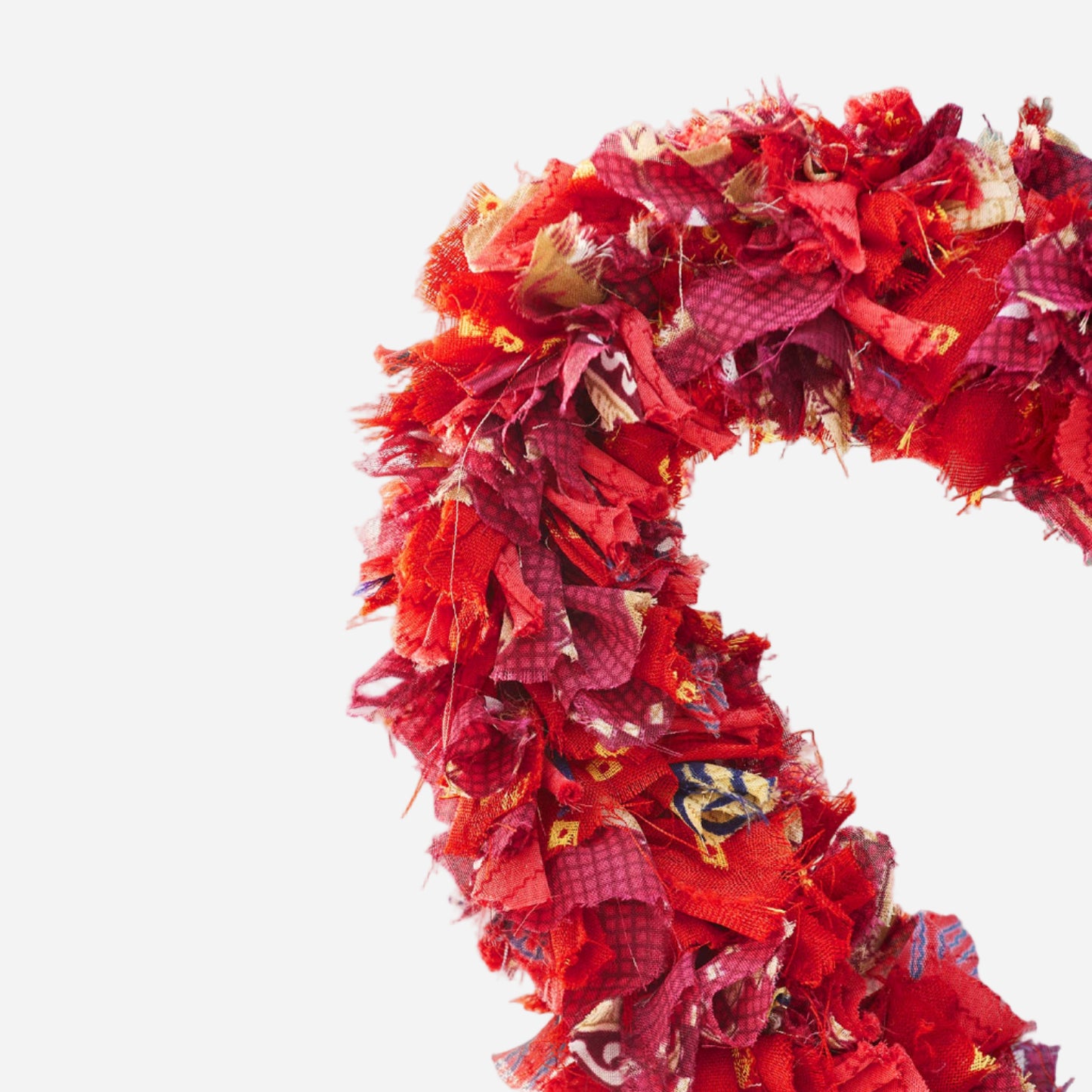 Red recycled sari fabric wreath on grey background