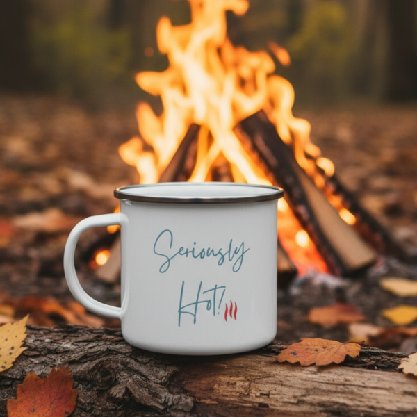White mug with 'Seriously Hot!' text on a log with a camp fire in the background