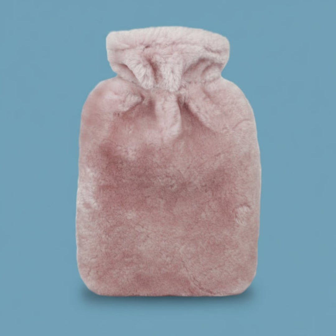 Pink sheepskin hot water bottle on a white background