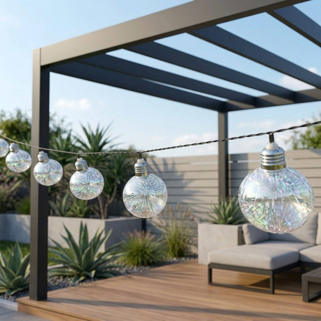 Decorative string lights hanging from a pergola on an outdoor patio in sunny garden.