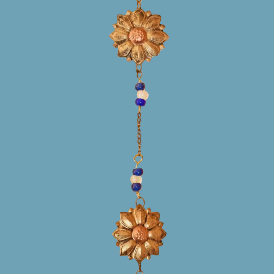 Decorative hanging chain with floral ends on a blue background