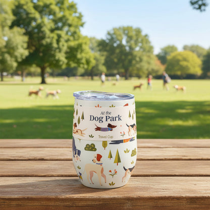 Tumbler with 'At the Dog Park' design on a wooden table in a park setting