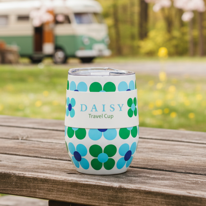Floral-patterned travel cup with 'DAISY' branding on a wooden surface outdoors.