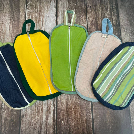 Set of colorful zippered pouches and pot holders on a wooden surface