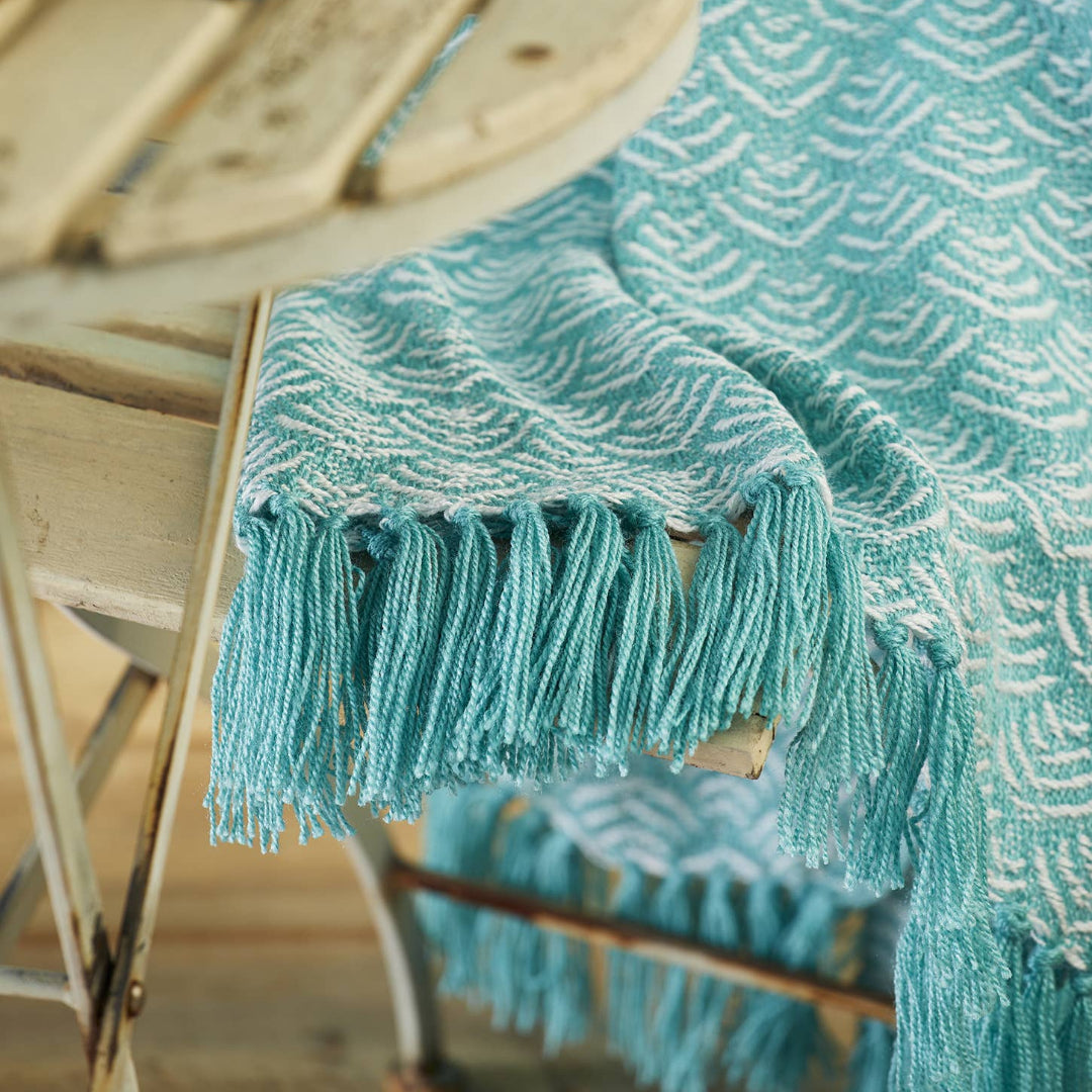 Turquoise woven blanket draped over a chair 