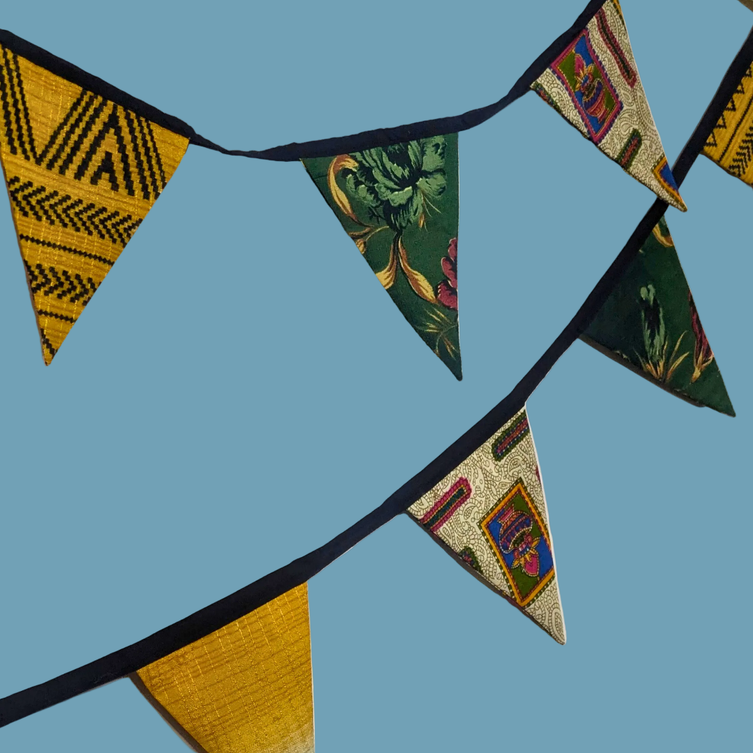 Colorful fabric bunting with geometric patterns on a blue background